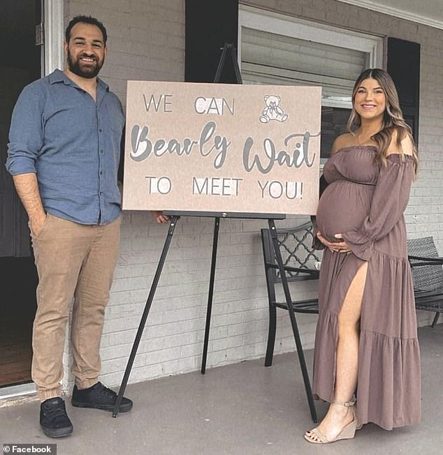 The couple posed at their elaborate baby shower next to a sign that read 