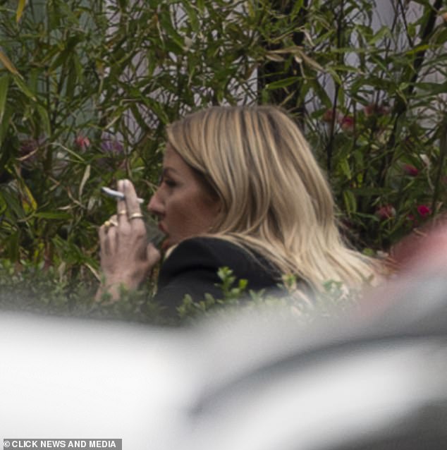 Ellie was sitting outside the restaurant smoking a cigarette.