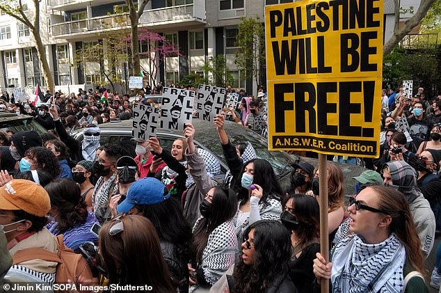 Pro-Palestinian protesters hold signs expressing their views outside New York University's John A. Paulson Center on May 3.