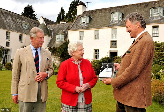 Queen Elizabeth and her son Charles, then Prince of Wales, are seen receiving a copy of the official biography of the Queen Mother written by author William Shawcross in 2009.