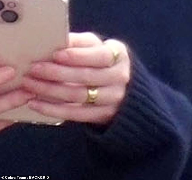 The actress, 28, flaunted a thick gold band on her engagement ring finger as she hinted that the property developer had popped the question.