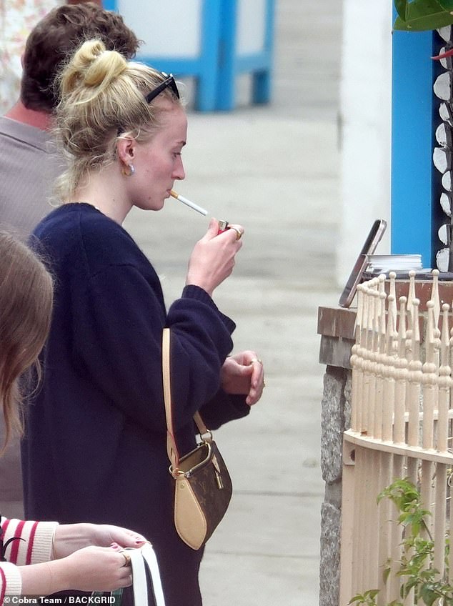 The star was also seen smoking a cigarette while embracing her natural beauty and appearing makeup-free for the outing.