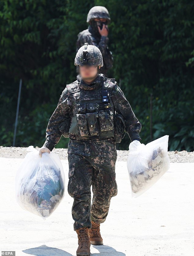 South Korean soldiers collect balloons allegedly sent by North Korea, found on a hill in Pyeongtaek on Wednesday. About 200 such balloons have been discovered so far across the country, military and police sources said, adding that they mainly contained garbage and other debris.