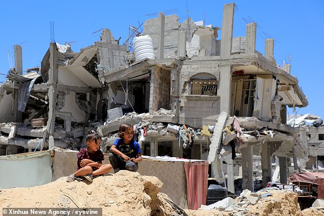 If talks are prolonged, the ceasefire would continue for as long as it takes to reach an agreement. Pictured: Palestinian children sitting near a destroyed house in the southern Gaza Strip.