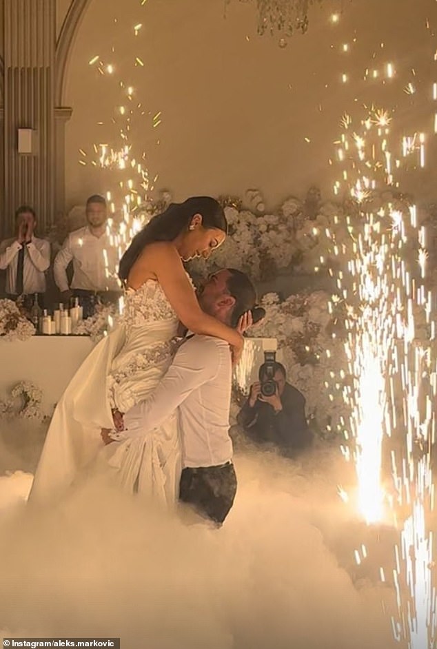 Images shared on Instagram capture the magical moment in which the couple shares a romantic dance surrounded by a cloud of fog, with Aleksandra holding a bouquet of white flowers.