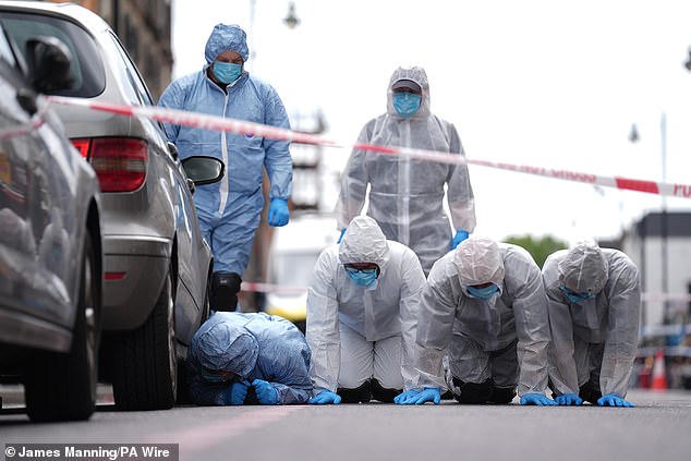 The nine-year-old girl is fighting for her life. Forensic officers are pictured at the scene on Thursday.