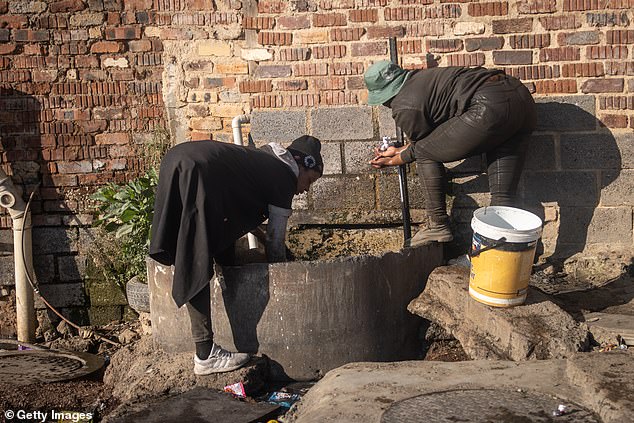 Women collect drinking water in an informal settlement in Alexandra township on May 31, 2024 in Johannesburg.