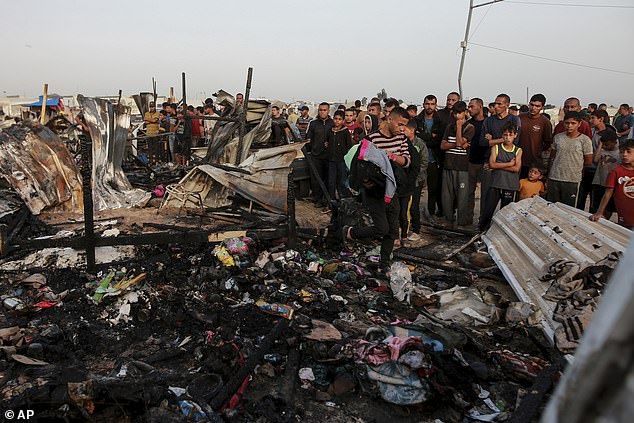 Palestinians observe the destruction following an Israeli attack where displaced people were staying in Rafah, Gaza Strip.