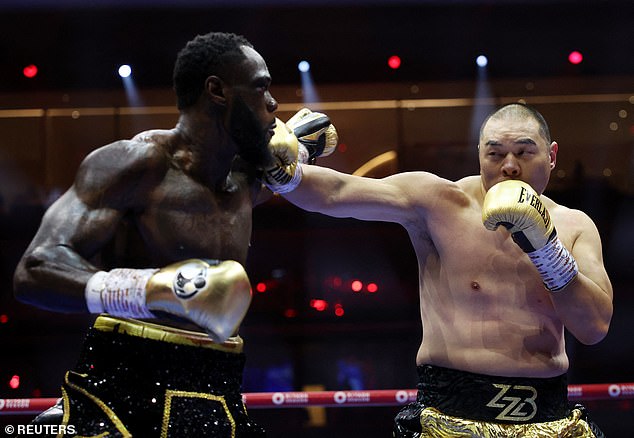 Wilder (left) was defeated by Zhilei Zhang via fifth-round knockout (right) during Saturday night's 5v5 event.