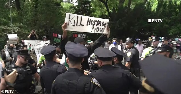 Police officers were seen trying to arrest the vile protester, who was wearing a mask to hide his face.