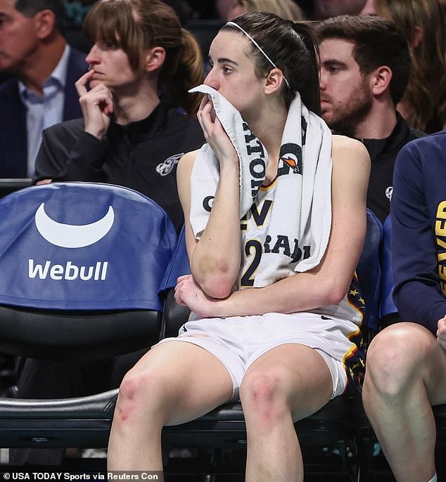 Clark watches from the bench as New York heavily defeats the Fever on Sunday night.