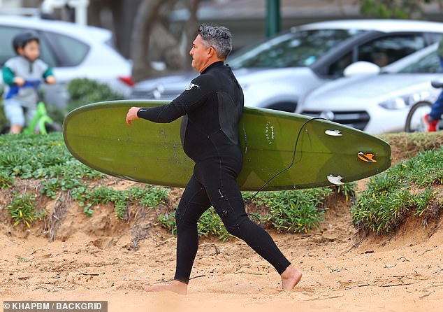 He could be seen walking through the sand with the board in his hand.