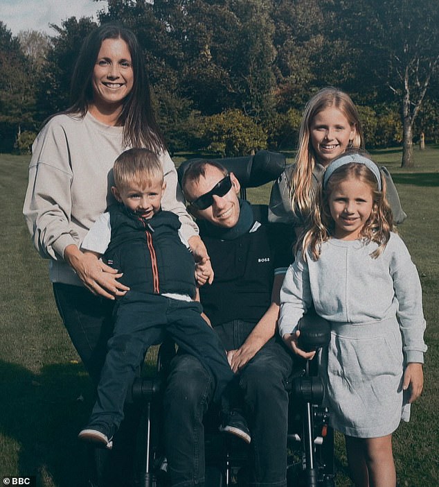 Rob posing with his wife Lindsey (left), his oldest daughter Macy (back right), his second daughter Maya (front right), and his son Jackson (sitting on the arm of the wheelchair)