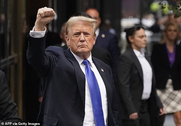 Former US President and Republican presidential candidate Donald Trump raises his fist as he returns to Trump Tower after being found guilty in his criminal trial.