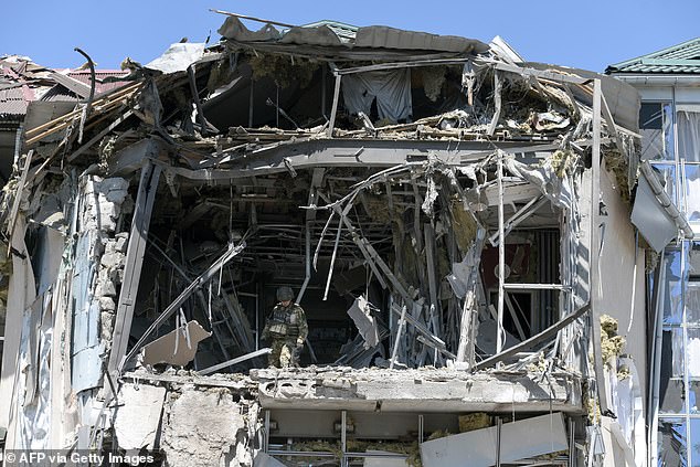 Military investigators work at the site of the damaged building that houses the Paradise restaurant following an attack in Donetsk, Russian-controlled Ukraine, earlier this month.