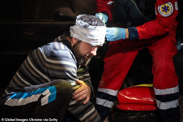 Doctors bandage the head of a man injured after a Russian bombing on May 31, 2024 in Kharkiv.