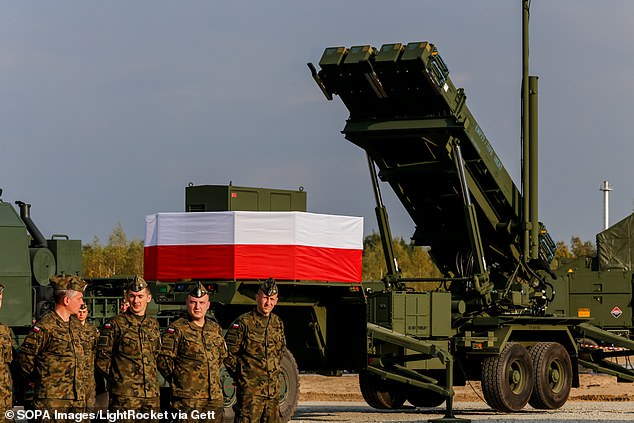 Army servicemen stand near a Patriot anti-aircraft battery