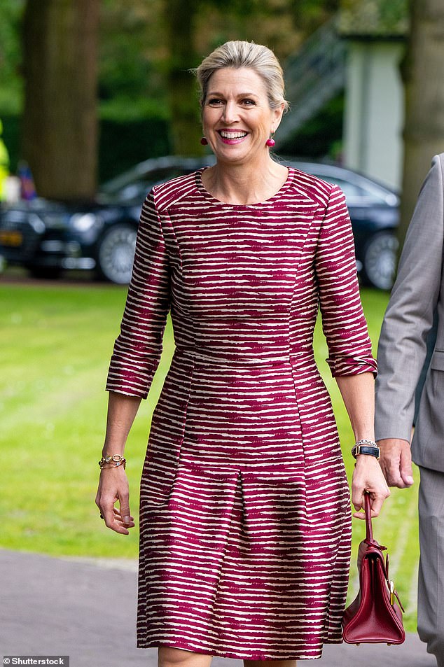 The smiling royal, 53, added a touch of glamor with a pair of red spherical earrings and gold bracelets.