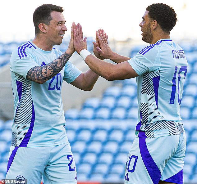 Che Adams (right) is applauded by Ryan Jack after doubling Scotland's lead.