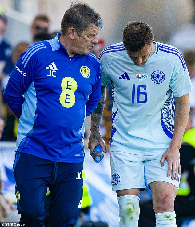 Scotland assistant manager John Carver speaks to defender Liam Cooper after he had to come off in the second half, although it is not believed to be serious.