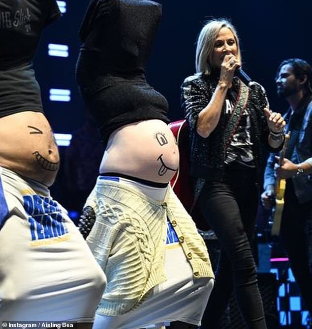 In one image, Aisling and Seth danced around the stage with their bellies on display as Sheryl performed.