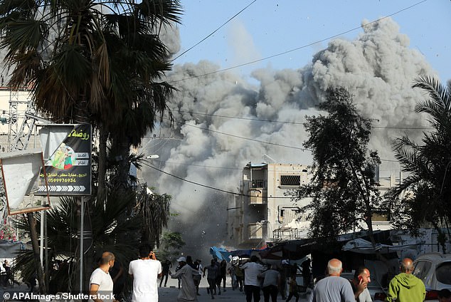 Dust and black smoke rise moments after an Israeli airstrike targeted a residential building in the town of Bureij.