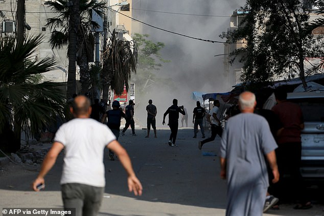 Palestinians run moments after Israeli airstrike targets residential building