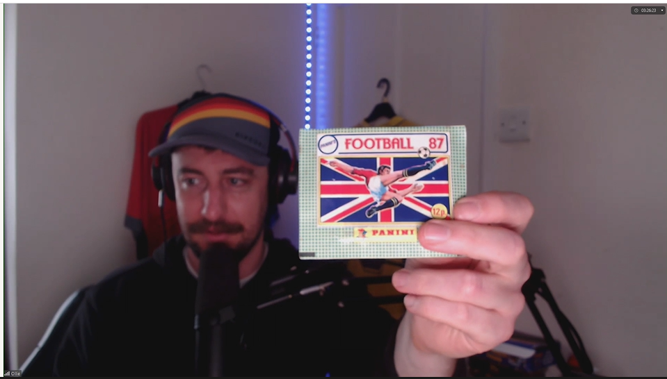 Ollie Jenks holding a starter pack of 1987 Panini football stickers