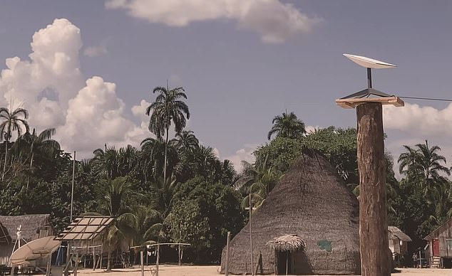 Satellite equipment is displayed outside the hut of a Marubo settlement.