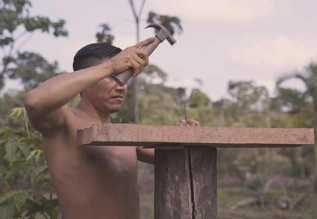 A tribesman builds a pedestal to house a satellite dish.