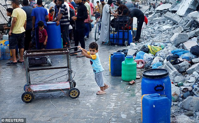 A Palestinian child next to water containers, in the midst of the current conflict between Israel and Hamas.