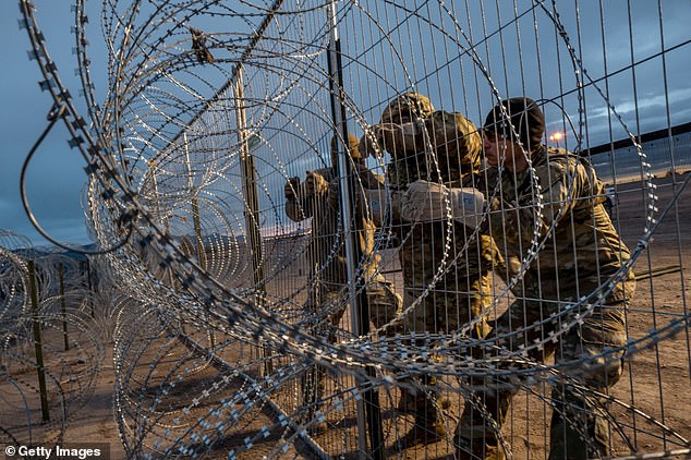 The order could block illegal immigration at the southern border once apprehensions reach a certain threshold per day. Pictured: Members of the Texas National Guard install a barbed wire border fence in El Paso on April 2.