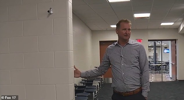 A school official shows off the wing walls on a tour after the school was built.