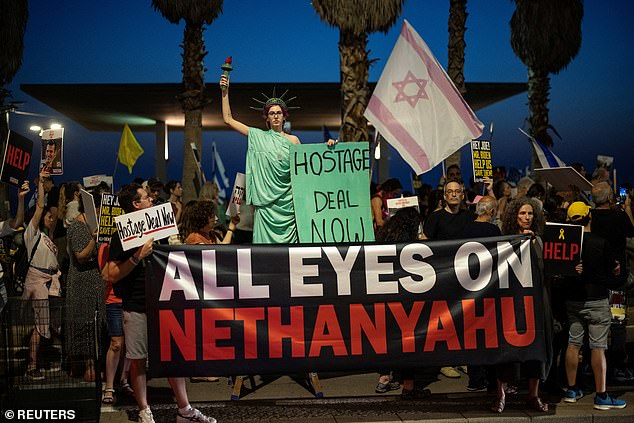 A protester poses by the Statue of Liberty as supporters and relatives of the hostages, who were kidnapped during the deadly October 7 attack by the Palestinian Islamist group Hamas,