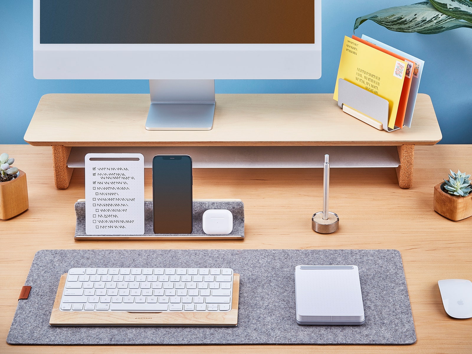 Simple two-tier wooden shelf on a desk with a computer monitor on top and additional accessories around it, such as...