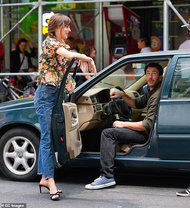 Dakota rested on the car door as the pair appeared to chat with a crew member.