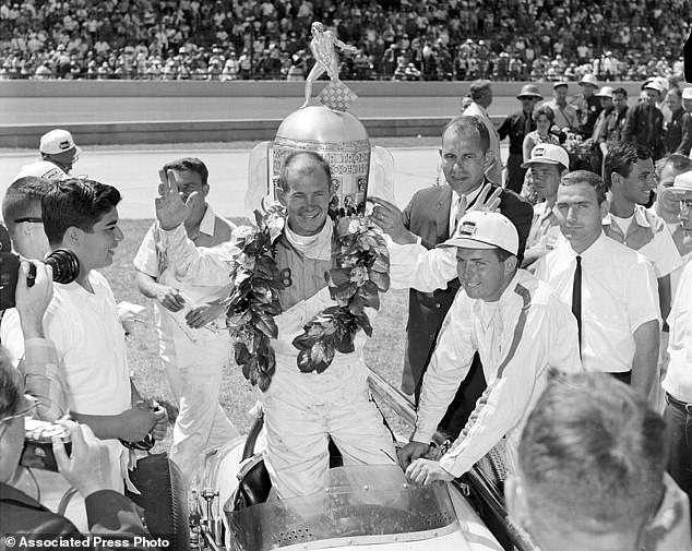 Jones celebrates his Indy 500 victory in front of the Borg-Warner Trophy in 1963