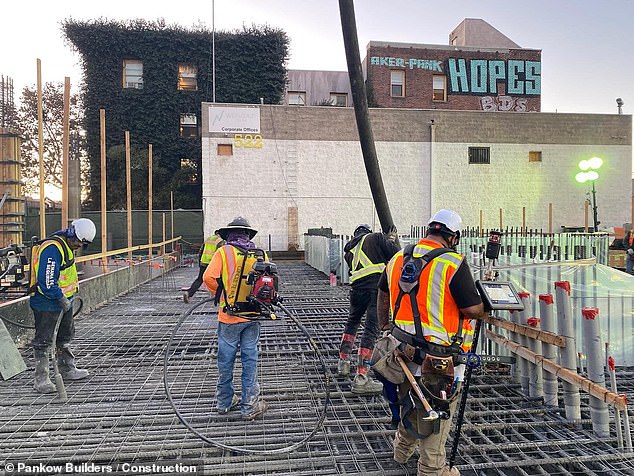 The units are furnished with durable but not flashy materials, and balconies have been built into each to prevent people from gathering in front of their buildings. Pictured: Workers building one of the company's new skyscrapers for the homeless.