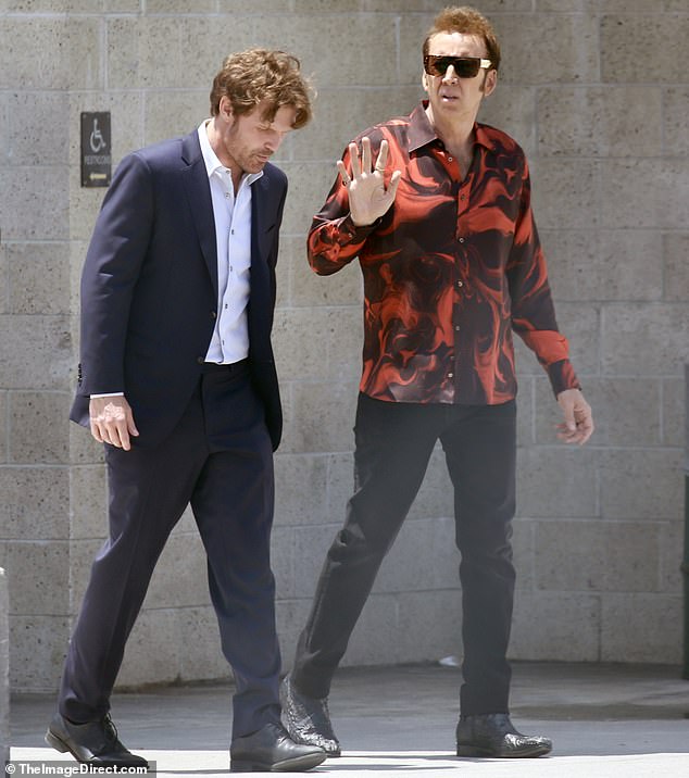 The 60-year-old changed his outfit for his scene with Scott Haze, this time opting for a red and maroon printed shirt and black pants. His co-star was wearing a dark blue two-piece suit and a white collared shirt.