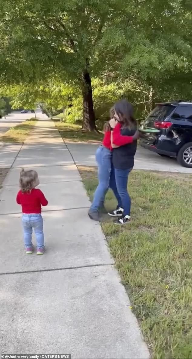 The young girl opens her mouth in shock and instantly hugs her adoptive mother before bursting into tears.