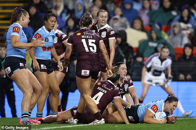 The Blues' Keeley Davis scores a try in the pouring rain during the second game of the Women's State of Origin