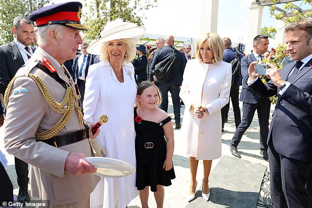 President Macron was seen taking a photo of the King and Queen with a young fan.