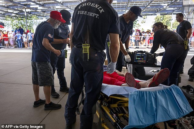 A Trump supporter is treated for exhaustion Friday in Phoenix after crowds waited for hours outside the event, held at a megachurch, as temperatures reached 110 degrees.