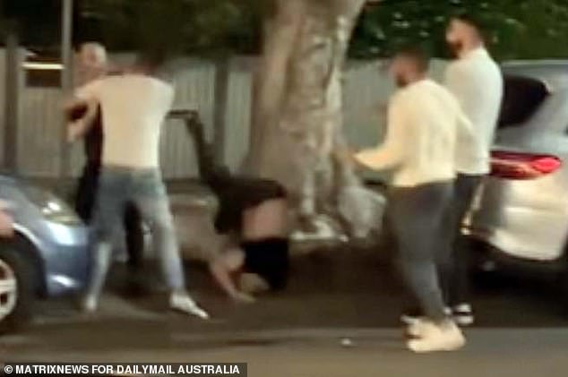 Footage of the alleged fight showed Kent (centre) landing head-first in a gutter after being thrown against a tree outside a Sydney pub. Uzun appears dressed in black on the left.