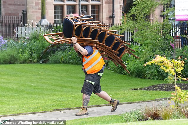 A worker carried a pile of chairs through the garden of Chester Cathedral on Thursday, the day before the wedding.