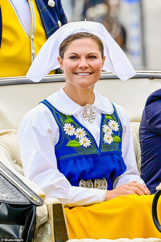 Crown Princess Victoria wore a traditional dress consisting of a white blouse with a blue tabard embroidered with flowers, a yellow peplum and a white headscarf.