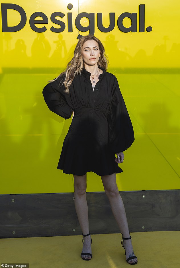 Paris looked elegant in a black button-down shirt dress with long flutter sleeves and a short ruffled skirt while attending the Desigual show.