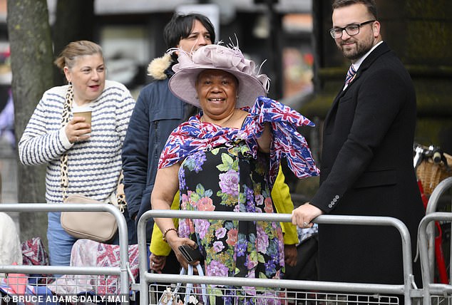 A woman dresses in a wedding dress and a Union Jack scarf outside the cathedral