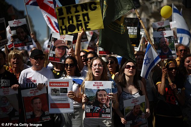 Protesters with banners, including one of hostage Noa Argamani (center), take part in a demonstration. "United we take them home" March, central London