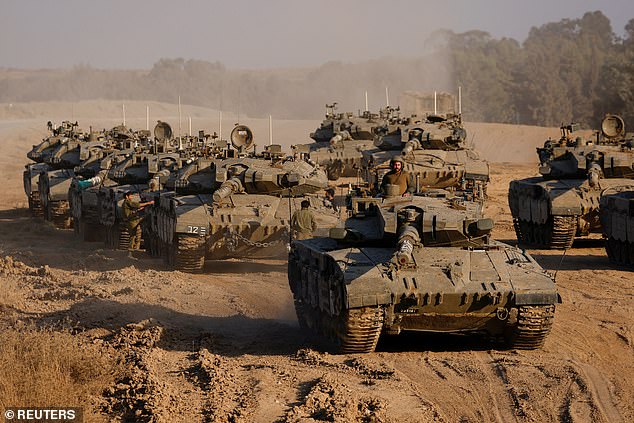 An Israeli soldier stands on a tank, amid the ongoing conflict between Israel and Hamas, near the Israel-Gaza border in Israel.